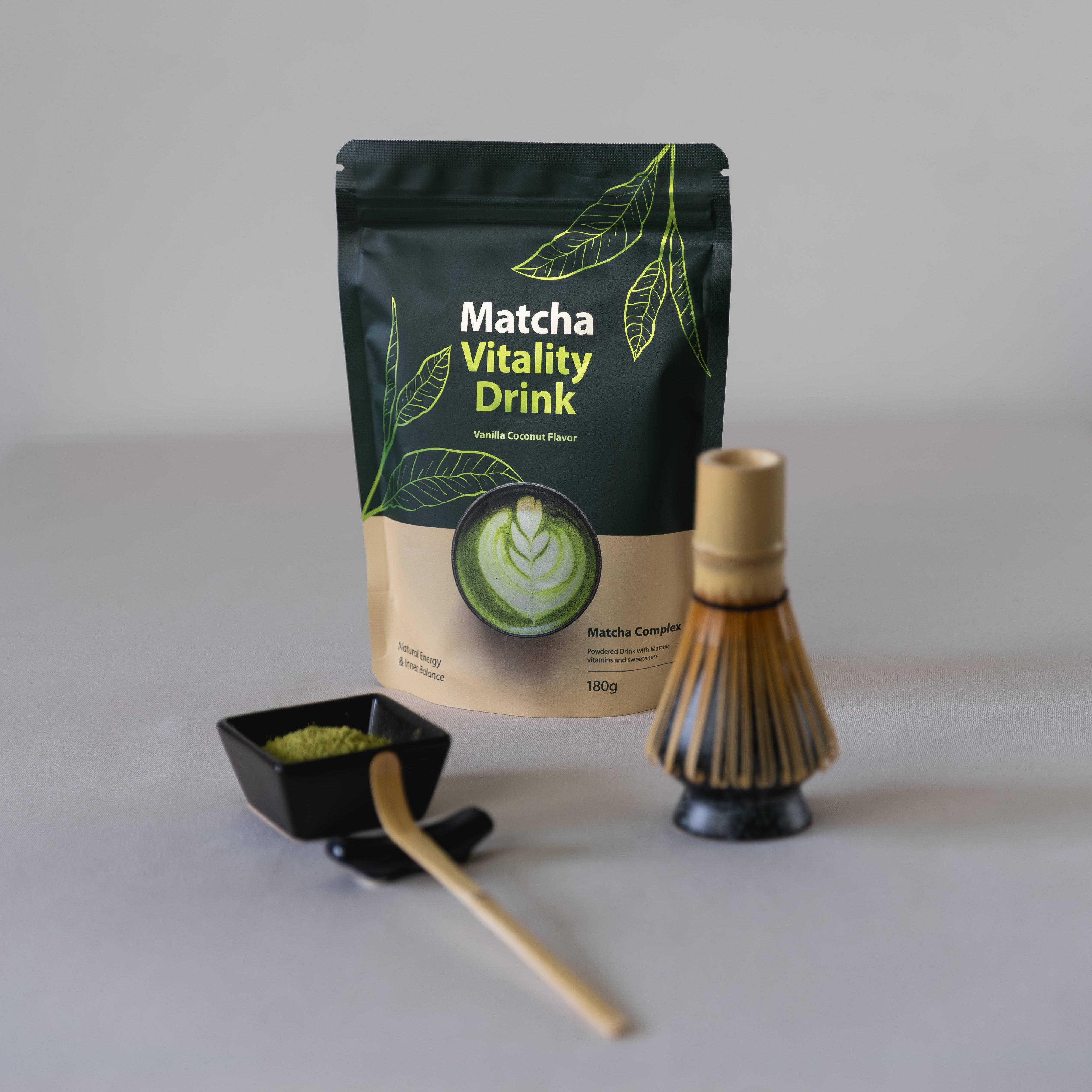 Bio Matcha Vitality Drink mit Kollagen von tigogreen: Packung neben Matcha-Besen, Pulverschale und Bambuslöffel.