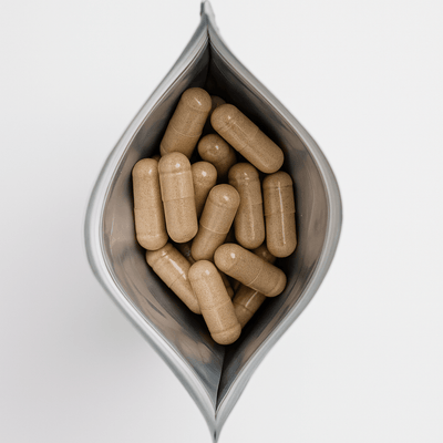 Draufsicht auf vegane tigofem Frauenmantelextrakt-Kapseln im geöffneten Refill-Nachfüllpack auf weißem Hintergrund.