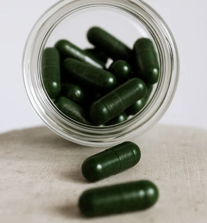 Detailaufnahme der grünen tigovit EGCG Kapseln in einer Glasflasche des nachhaltigen Grüntee-Extrakt Starter Pakets.